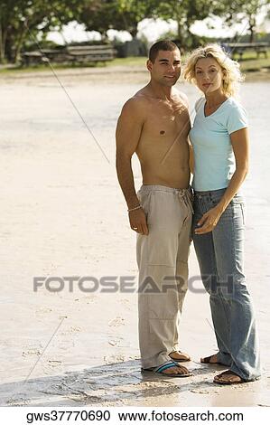 Portrait of a young couple standing on the beach View Large Photo Image Stock Image - Portrait of a young couple standing on the beach. Fotosearch