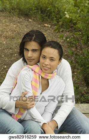 Portrait of a young man embracing a young woman from behind View Large Photo Image Stock Photo - Portrait of a young man embracing a young woman from behind. Fotosearch