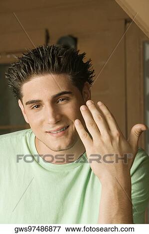 Portrait of a young man gesturing with his finger View Large Photo Image Stock Photo - Portrait of a young man gesturing with his finger. Fotosearch