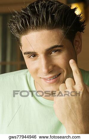 Portrait of a young man gesturing with his finger View Large Photo Image Stock Photograph - Portrait of a young man gesturing with his finger. Fotosearch