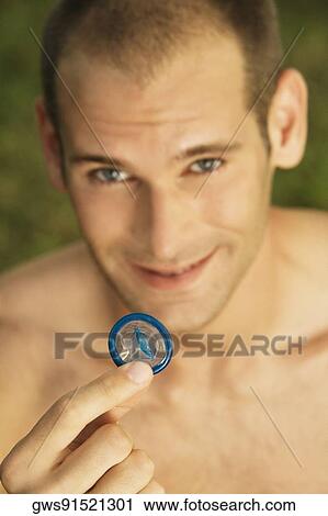 Portrait of a young man holding a condom View Large Photo Image Stock Image - Portrait of a young man holding a condom. Fotosearch