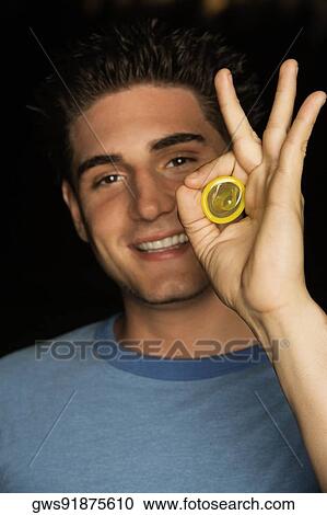 Portrait of a young man holding a condom View Large Photo Image Stock Image - Portrait of a young man holding a condom. Fotosearch