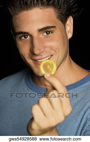 Portrait of a young man holding a condom View Large Photo Image Stock Photo - Portrait of a young man holding a condom. Fotosearch