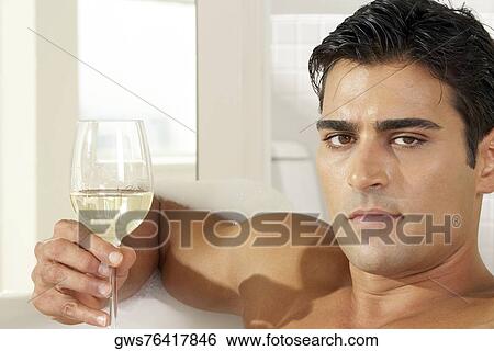 Portrait of a young man holding a glass of white wine View Large Photo Image Stock Photograph - Portrait of a young man holding a glass of white wine. Fotosearch