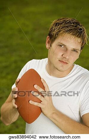 Portrait of a young man holding a rugby ball View Large Photo Image Stock Image - Portrait of a young man holding a rugby ball. Fotosearch