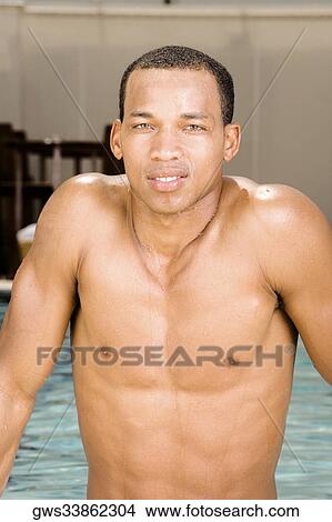 Portrait of a young man leaning against the edge of a swimming pool View Large Photo Image Picture - Portrait of a young man leaning against the edge of a swimming pool. Fotosearch