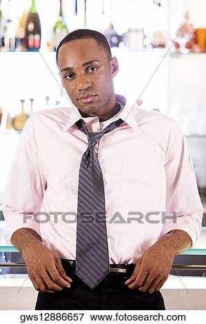 Portrait of a young man leaning against a bar counter View Large Photo Image Stock Photo - Portrait of a young man leaning against a bar counter. Fotosearch