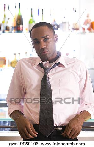Portrait of a young man leaning against a bar counter View Large Photo Image Stock Photograph - Portrait of a young man leaning against a bar counter. Fotosearch