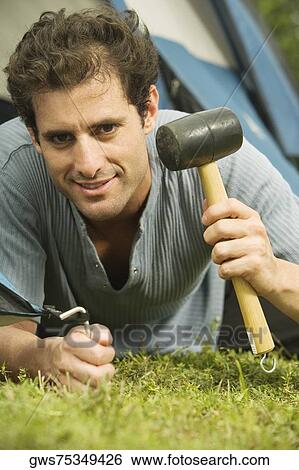Portrait of a young man putting up a tent View Large Photo Image Stock Photograph - Portrait of a young man putting up a tent. Fotosearch