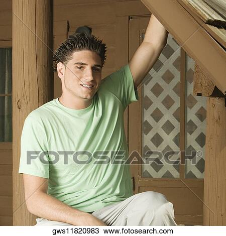 Portrait of a young man sitting on the porch smiling View Large Photo Image Stock Image - Portrait of a young man sitting on the porch smiling. Fotosearch