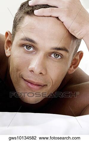 Portrait of a young man smirking View Large Photo Image Stock Image - Portrait of a young man smirking. Fotosearch