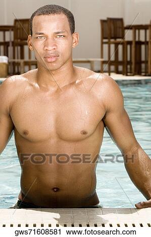 Portrait of a young man standing in a swimming pool View Large Photo Image Stock Image - Portrait of a young man standing in a swimming pool. Fotosearch