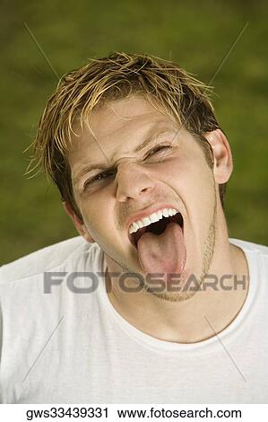 Portrait of a young man sticking out his tongue View Large Photo Image Stock Image - Portrait of a young man sticking out his tongue. Fotosearch