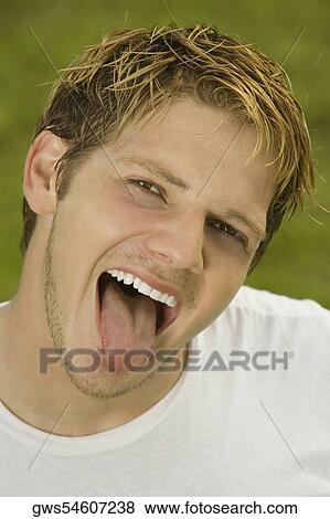 Portrait of a young man sticking out his tongue View Large Photo Image Stock Photo - Portrait of a young man sticking out his tongue. Fotosearch