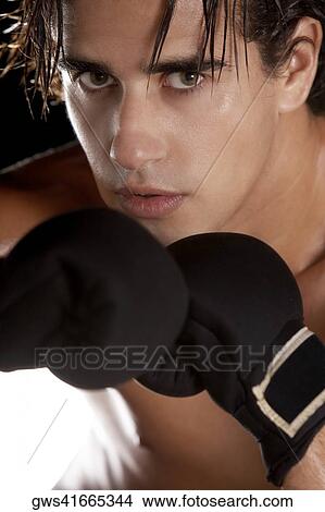 Picture - Portrait of a young man wearing boxing gloves. Fotosearch