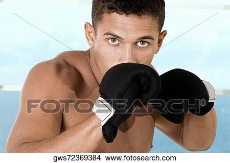 Portrait of a young man wearing boxing gloves View Large Photo Image Picture - Portrait of a young man wearing boxing gloves. Fotosearch