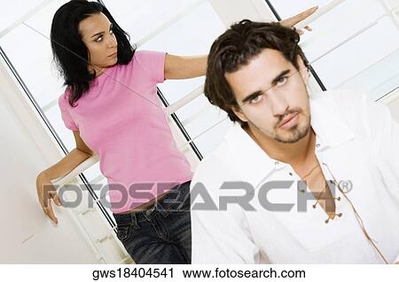 Portrait of a young man with a young woman leaning against the railing behind him View Large Photo Image Stock Image - Portrait of a young man with a young woman leaning against the railing behind him. Fotosearch