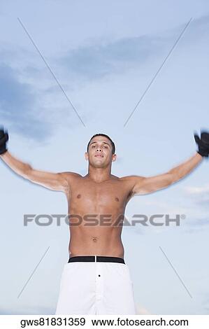 Portrait of a young man with his arms raised View Large Photo Image Stock Photo - Portrait of a young man with his arms raised. Fotosearch