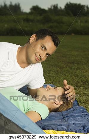 Portrait of a young man with his hand on a young woman's head View Large Photo Image Stock Photo - Portrait of a young man with his hand on a young woman's head. Fotosearch