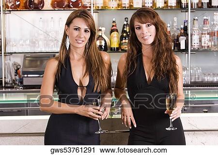 Portrait of a young woman and a mid adult woman leaning against a bar counter View Large Photo Image Stock Image - Portrait of a young woman and a mid adult woman leaning against a bar counter. Fotosearch