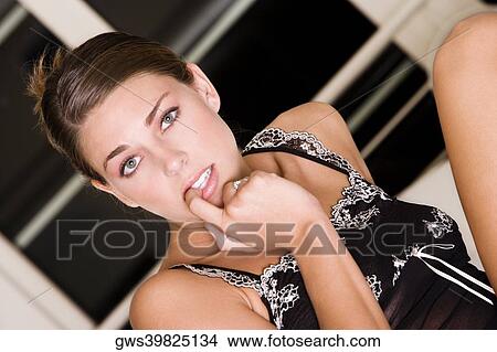Portrait of a young woman biting her finger nails View Large Photo Image Picture - Portrait of a young woman biting her finger nails. Fotosearch