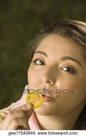 Portrait of a young woman blowing a condom View Large Photo Image Stock Photography - Portrait of a young woman blowing a condom. Fotosearch