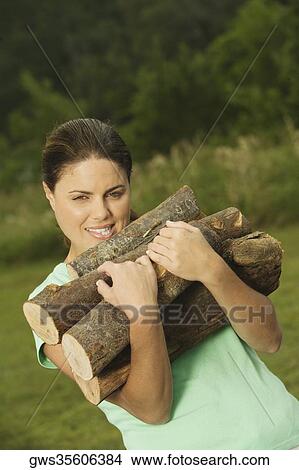 Portrait of a young woman carrying firewood View Large Photo Image Picture - Portrait of a young woman carrying firewood. Fotosearch