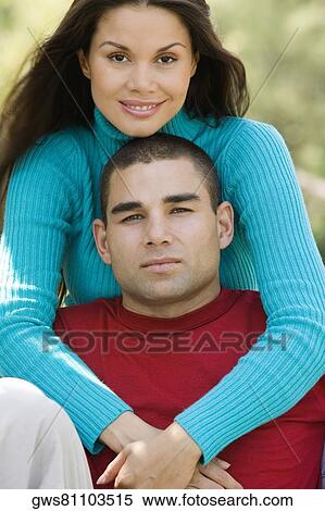 Stock Photography - Portrait of a young woman embracing a young man. Fotosearch