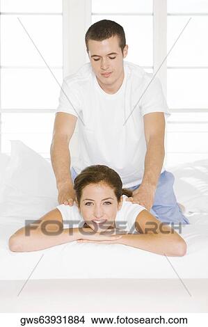 Portrait of a young woman getting a back massage from a young man View Large Photo Image Picture - Portrait of a young woman getting a back massage from a young man. Fotosearch