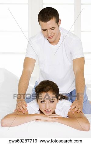 Portrait of a young woman getting a back massage from a young man View Large Photo Image Stock Photo - Portrait of a young woman getting a back massage from a young man. Fotosearch