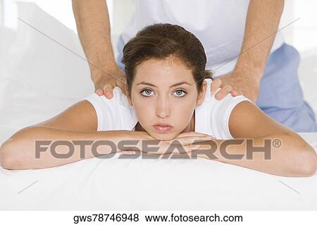 Portrait of a young woman getting a back massage from a young man View Large Photo Image Stock Photo - Portrait of a young woman getting a back massage from a young man. Fotosearch