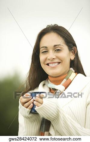 Portrait of a young woman holding a cup View Large Photo Image Stock Image - Portrait of a young woman holding a cup. Fotosearch