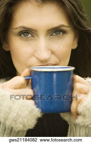 Portrait of a young woman holding a mug View Large Photo Image Stock Image - Portrait of a young woman holding a mug. Fotosearch