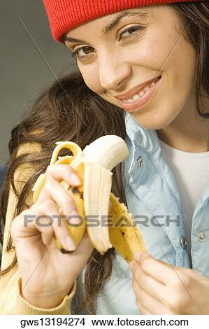 Portrait of a young woman holding a banana View Large Photo Image Picture - Portrait of a young woman holding a banana. Fotosearch