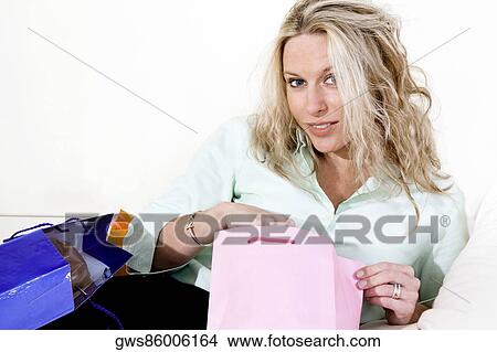 Portrait of a young woman holding a shopping bag View Large Photo Image Picture - Portrait of a young woman holding a shopping bag. Fotosearch