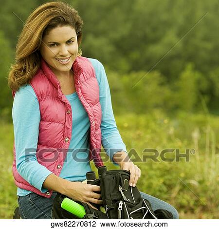 Portrait of a young woman holding a pair of binoculars View Large Photo Image Stock Image - Portrait of a young woman holding a pair of binoculars. Fotosearch