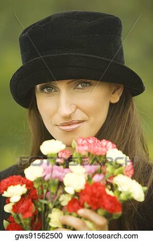 Stock Image - Portrait of a young woman holding a bouquet of flowers. Fotosearch