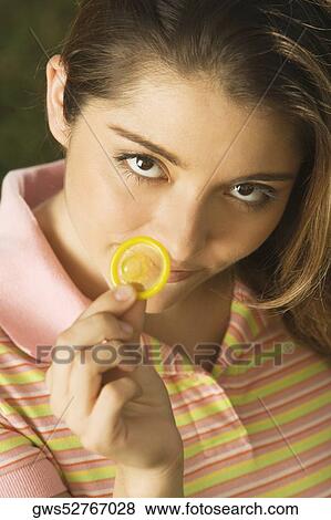 Portrait of a young woman holding a condom View Large Photo Image Stock Photo - Portrait of a young woman holding a condom. Fotosearch