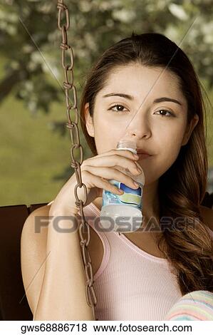 Portrait of a young woman holding a water bottle View Large Photo Image Stock Photo - Portrait of a young woman holding a water bottle. Fotosearch