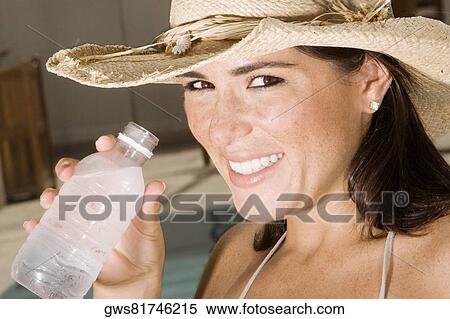Portrait of a young woman holding a water bottle View Large Photo Image Stock Photography - Portrait of a young woman holding a water bottle. Fotosearch
