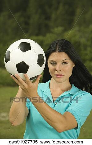 Portrait of a young woman holding a soccer ball View Large Photo Image Stock Photography - Portrait of a young woman holding a soccer ball. Fotosearch