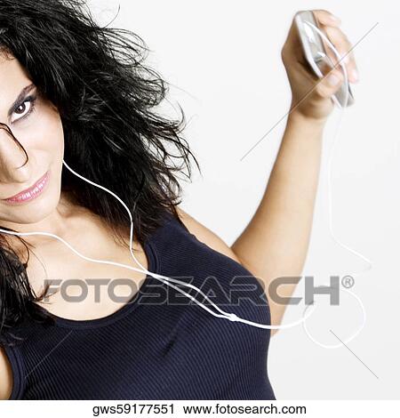 Portrait of a young woman holding an MP3 player View Large Photo Image Stock Image - Portrait of a young woman holding an MP3 player. Fotosearch