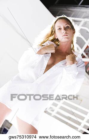 Portrait of a young woman holding her shirt collar View Large Photo Image Picture - Portrait of a young woman holding her shirt collar. Fotosearch