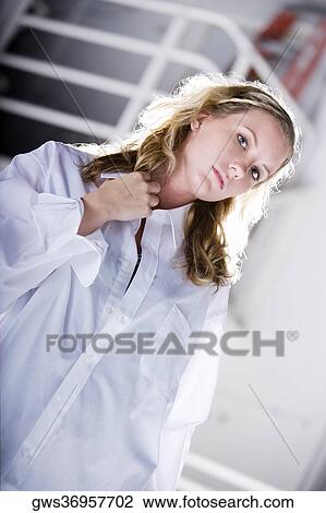 Portrait of a young woman holding her shirt collar View Large Photo Image Stock Image - Portrait of a young woman holding her shirt collar. Fotosearch