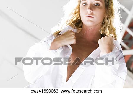 Portrait of a young woman holding her shirt collar View Large Photo Image Stock Image - Portrait of a young woman holding her shirt collar. Fotosearch