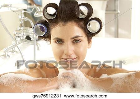 Portrait of a young woman in a bathtub with curlers in her hair View Large Photo Image Stock Image - Portrait of a young woman in a bathtub with curlers in her hair. Fotosearch
