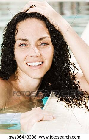Portrait of a young woman leaning at the edge of a swimming pool View Large Photo Image Stock Photo - Portrait of a young woman leaning at the edge of a swimming pool. Fotosearch