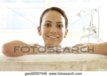 Portrait of a young woman leaning at the edge of a bathtub View Large Photo Image Stock Photograph - Portrait of a young woman leaning at the edge of a bathtub. Fotosearch