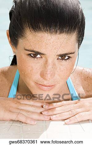 Portrait of a young woman leaning against the edge of a swimming pool View Large Photo Image Stock Image - Portrait of a young woman leaning against the edge of a swimming pool. Fotosearch