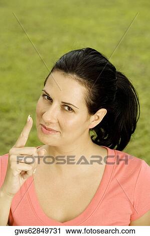 Portrait of a young woman pointing up View Large Photo Image Stock Image - Portrait of a young woman pointing up. Fotosearch